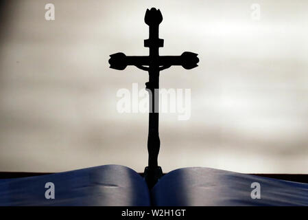 Kruzifix und offene Bibel auf dem Altar. Stockfoto