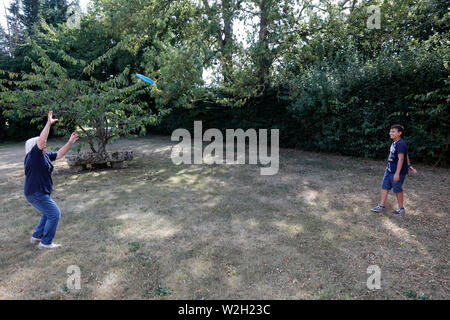 Der 12-jährige Junge spielt Frisbee mit seiner Großmutter in Bosc-Renoult, Frankreich. Stockfoto