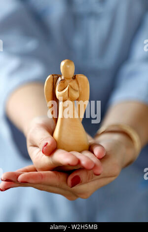 Hände von einer Frau mit einem Engel. Close-up. Stockfoto