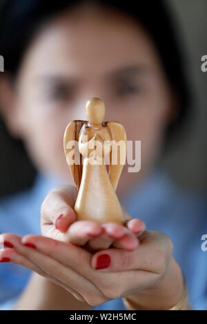 Hände von einer Frau mit einem Engel. Close-up. Stockfoto