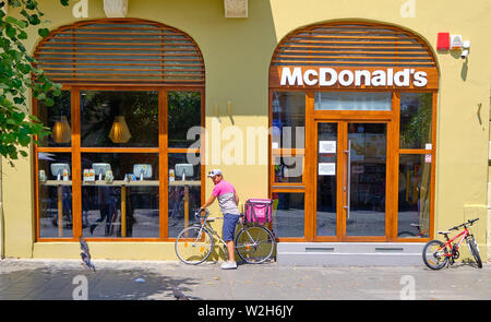 Sibiu, Rumänien. Essen Panda, ein Lebensmittel Lieferservice, Radfahrer vor einem McDonalds Restaurant herauf eine Bestellung für einen Kunden. Stockfoto