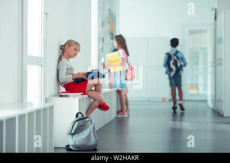 Schülerin sitzt auf der Fensterbank und das Wiederholen von Informationen Stockfoto