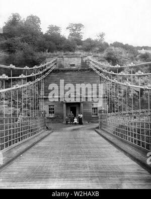 Die Union Kettenbrücke und Toll House auf der englischen Seite der Brücke. Das Foto wurde in ca. 1899/1900 und die mit dem Roxburgh außerhalb ihrer Familie mit nach Hause genommen. Die Toll House wurde in den 1950er Jahren abgerissen. Die Brücke trägt noch Fahrzeugverkehr und ist die älteste Hängebrücke der Welt noch so tut. Überquerung des Flusses Tweed zwischen England und Schottland. Die Brücke ist in der Nähe von Berwick upon Tweed und wurde von Kapitän Samuel Braun RN konzipiert. Stockfoto