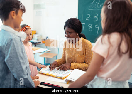 Professionelle Lehrer der Grundschule sprechen mit Schülern Stockfoto