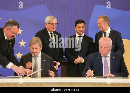 Kiew, Ukraine. 8. Juli, 2019. Präsident der Ukraine Volodymyr Zelenskiy (C), der Präsident des Europäischen Rates Donald Tusk (R) und des Präsidenten der Europäischen Kommission, Jean-Claude Juncker (L) stehen hinter der Europäische Kommissar für Europäische Nachbarschaftspolitik und Erweiterung Verhandlungen Johannes Hahn und vice-PM Stepan Kubiv Unterzeichnung einer Vereinbarung während des Gipfels in Kiew, Ukraine, 8. Juli 2019. Das 21. Gipfeltreffen EU-Ukraine findet in Kiew mit Besuch des Präsidenten des Europäischen Rates und der Europäischen Kommission. Credit: sergii Kharchenko/ZUMA Draht/Alamy leben Nachrichten Stockfoto
