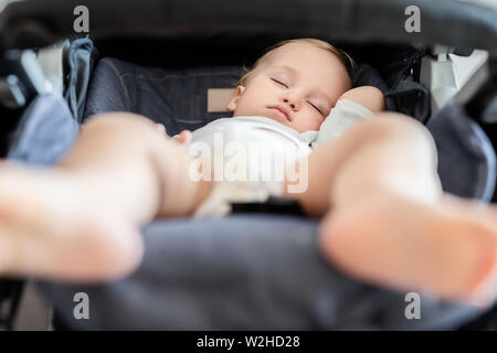 Cute adorable kaukasischen blonden Kleinkind bou schlafen im Kinderwagen bei Tag. Kinder Gesundheit und glückliche Kindheit Konzept Stockfoto