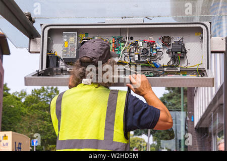 Ingenieur Überprüfung, Reparatur, RTPI Anzeige unterzeichnen, Echtzeit, Fahrgastinformation, elektronische digitale Daten unterzeichnen, in der Wartehalle in Bournemouth Stockfoto