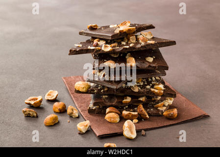 Haselnuss dunkle Schokolade Stücke auf braunem Hintergrund Stockfoto
