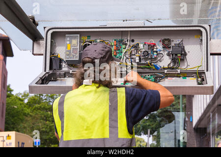 Ingenieur Überprüfung, Reparatur, RTPI Anzeige unterzeichnen, Echtzeit, Fahrgastinformation, elektronische digitale Daten unterzeichnen, in der Wartehalle in Bournemouth Stockfoto