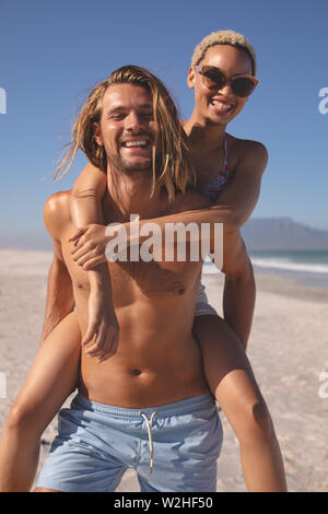 Mann, piggyback Ride zu Frau am Strand Stockfoto