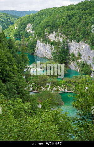 Hetzen, reines, frisches Wasser ergiesst sich die natürliche Hindernisse in den türkisfarbenen See Kaluđerovac im Nationalpark Plitvicer Seen in Kroatien Stockfoto