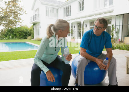 Active Senior paar Miteinander reden nach dem Training in der Halle zu Hause. Stockfoto