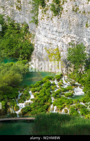 Hetzen, reines, frisches Wasser ergiesst sich die natürliche Hindernisse in den türkisfarbenen See Kaluđerovac im Nationalpark Plitvicer Seen in Kroatien Stockfoto