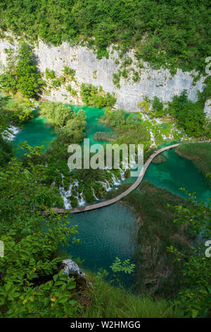 Hetzen, reines, frisches Wasser ergiesst sich die natürliche Hindernisse in den türkisfarbenen See Kaluđerovac im Nationalpark Plitvicer Seen in Kroatien Stockfoto