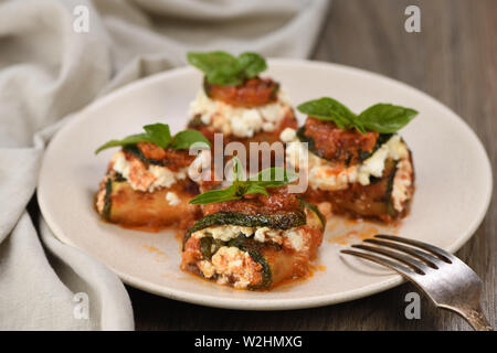 Gebackene Zucchini Brötchen gefüllt mit Ricotta und Basilikum unter Tomaten - Zwiebel - Sauce Stockfoto