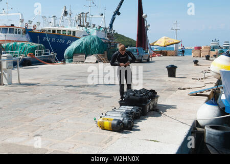 8. 28. 2012. Vrsar. Kroatien. Diver Kontrollen Sauerstoffflaschen für Tauchen auf der Pier. Volle Sauerstoffflaschen und Tauchausrüstung bereit zu tauchen. Stockfoto