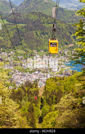 Gelbe Gondel der Seilbahn Zwoelferhorn (Seilbahn) Reisen nach oben und unten alpine Peak mit einem Blick auf den Ort St. Gilgen und den Wolfgangsee See Stockfoto