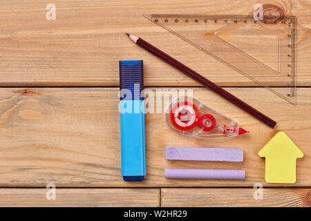 Schulbedarf auf Holzhintergrund. Stockfoto