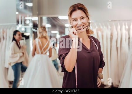 Lächelnd zugeschnitten, die ihre Brille in Ihrem Laden stehen. Stockfoto