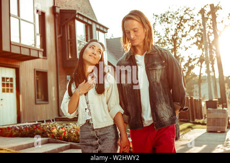 Langhaarige asiatische Mädchen wird mit Komplimenten des Blonden Kerl aufgeregt Stockfoto