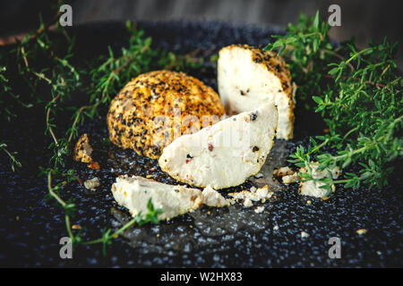 Delikatesse runden Käse Belper Knoll mit Gemüse und Kräutern auf einem Holztisch. Frische Produkte vom Bauernhof in Russland Stockfoto