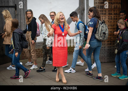 Drachenzähmen Thema Cressida Cowell lacht als Reisegruppe Spaziergang hinter ihr zu einem Fotoshooting im Shakespeare's Globe Theatre, London nach als neue Waterstones Children's Laureate an der Sam Wanamaker Playhouse, London angekündigt werden. Stockfoto