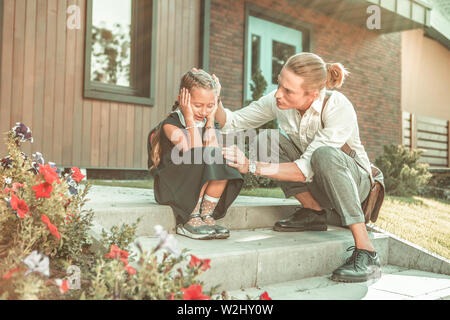 Verärgert kleines Mädchen in schwarzen Schuluniform verzweifelt schreien Stockfoto