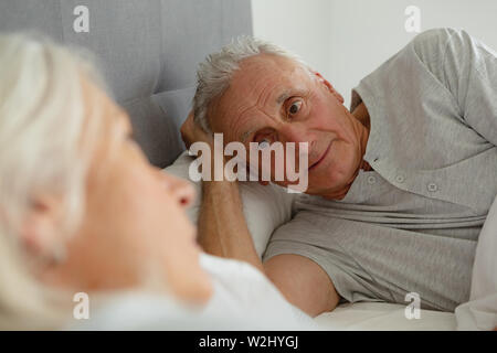 Älterer Mann im Gespräch mit älteren Frau, während im Schlafzimmer schlafen Stockfoto