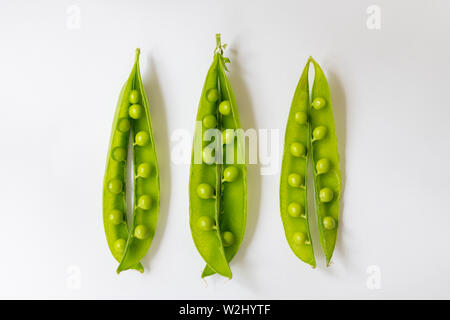 Drei frisch gepflückte Erbsen Pods auf weißem Hintergrund Stockfoto