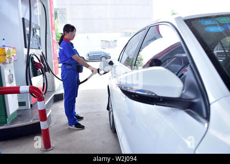 Hebei, Provinz Hebei, China. 9. Juli 2019. Hebei, China - 9. Juli 2019: Ein Arbeiter füllt sich ein Auto an einer Tankstelle in der Stadt xinle, Shijiazhuang, Provinz Hebei's North China Provinz, 9. Juli 2019. Nach den jüngsten Änderungen der Ölpreise auf dem internationalen Markt, entsprechend der aktuellen Preismechanismus für raffiniertes Öl. Die nationale Kommission für Entwicklung und Reform (NDRC) hat Preise für Benzin und Diesel von 150 Yuan angehoben und 140 Yuan pro Tonne, jeweils ab 24:00 Uhr am Juli 9, 2019. Credit: SIPA Asien/ZUMA Draht/Alamy leben Nachrichten Stockfoto