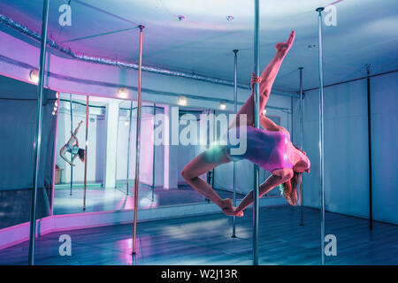 Zierliche Sportlerin Training vor dem Spiegel. Stockfoto