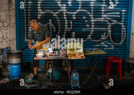 Bangkok, Thailand - 29.Juni 2019: Grandma Ein unbekannter Anbieter Vorbereitung Pad Thai Stall mit Ei an ihrer Garküche. Street Food. Stockfoto