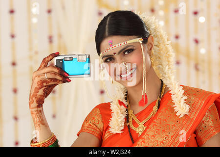 Indische Braut, die sich selbst fotografiert und lächelt Stockfoto