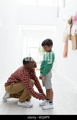 Vater seine Söhne Schnürsenkel binden zu Hause Stockfoto