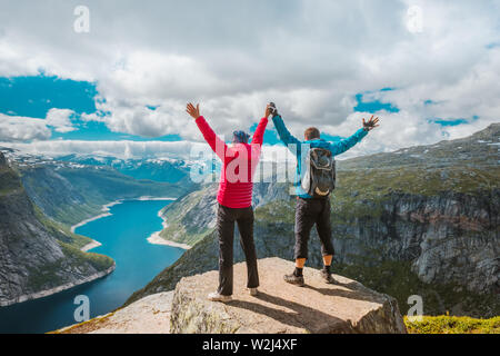 Paar posiert auf Trolltunga. Froh, dass Frau und Mann schönen See und gutes Wetter in Norwegen genießen. Stockfoto