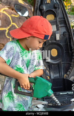 Asian Boy tanken Kraftstoff in die Motorrad Stockfoto