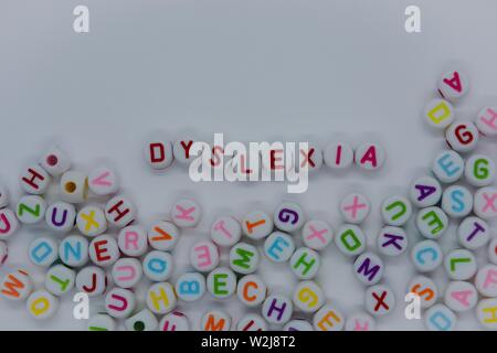 Legasthenie, in roten Buchstaben, die durch ein Meer von zufälligen Buchstaben umgeben, auf weißem Hintergrund mit kopieren. Kreatives Konzept: Lesen Behinderung Stockfoto
