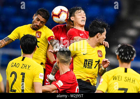 Brasilianische Fußballspieler Paulinho, links, von Guangzhou Evergrande Taobao leitet den Ball gegen Spieler von Tianjin Tianhai in der 15. Runde während der 2019 chinesischen Fußballverband Super League (CSL) in Tianjin, China, 5. Juli 2019. Guangzhou Evergrande Taobao besiegt Tianjin Tianhai 3-0. Stockfoto