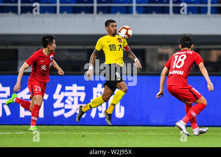 Brasilianische Fußballspieler Paulinho, oben, von Guangzhou Evergrande Taobao passt den Ball gegen Spieler von Tianjin Tianhai in der 15. Runde während der 2019 chinesischen Fußballverband Super League (CSL) in Tianjin, China, 5. Juli 2019. Guangzhou Evergrande Taobao besiegt Tianjin Tianhai 3-0. Stockfoto