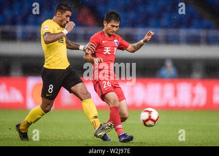 Brasilianische Fußballspieler Paulinho, links, von Guangzhou Evergrande Taobao passt den Ball gegen einen Spieler von Tianjin Tianhai in der 15. Runde während der 2019 chinesischen Fußballverband Super League (CSL) in Tianjin, China, 5. Juli 2019. Guangzhou Evergrande Taobao besiegt Tianjin Tianhai 3-0. Stockfoto