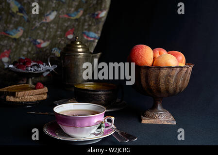 Hausgemachte Marmelade von Aprikosen. Frische Aprikosen eine Tasse schwarzen Tee und Toast mit Marmelade verteilen. Stockfoto