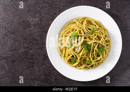 Spaghetti Pasta mit Pesto auf schwarzem Hintergrund. Ansicht von oben Stockfoto