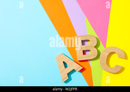 Buchstaben ABC gesäumt mit Holz Buchstaben auf mehrfarbigen Hintergrund Stockfoto