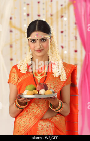 Porträt von einem indischen Braut Halteplatte und lächelnd Stockfoto