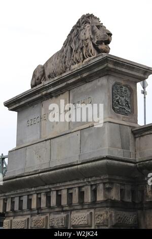 Eine von vier Löwen an den Enden der berühmten Wahrzeichen Kettenbrücke (Széchenyi lanczhid) in Budapest, Ungarn. Stockfoto