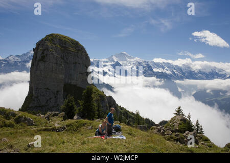 Wanderer auf der Schynige Platte, mit einem bezaubernden Blick auf das Gumihorn und schneebedeckten Gipfeln, einschließlich der Jungfrau in der Ferne, Schweiz Stockfoto