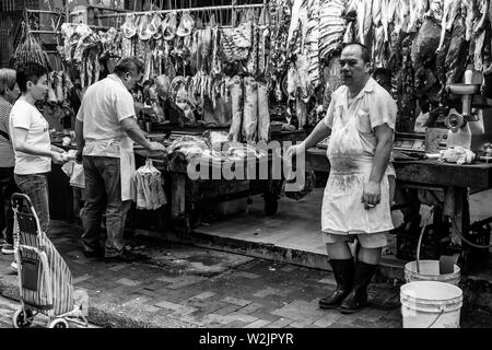 Die Menschen vor Ort kaufen Fleisch bei einem Metzger Shop im Bowrington Straße Food Market, Hongkong, China Stockfoto