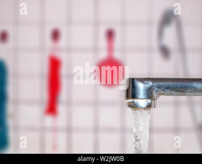 Öffnen Sie mit fließendem Wasser vor dem Hintergrund der Bad isoliert tippen und Dusche Stockfoto