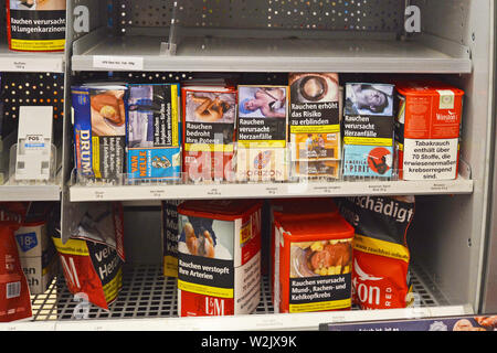 Regal mit Tabak für selbstgedrehte Zigaretten mit Warnhinweisen auf Sie in deutschen Supermarkt Stockfoto