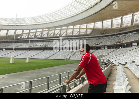 Nachdenklich African American male Rugby Spieler stehen im Stadion Stockfoto